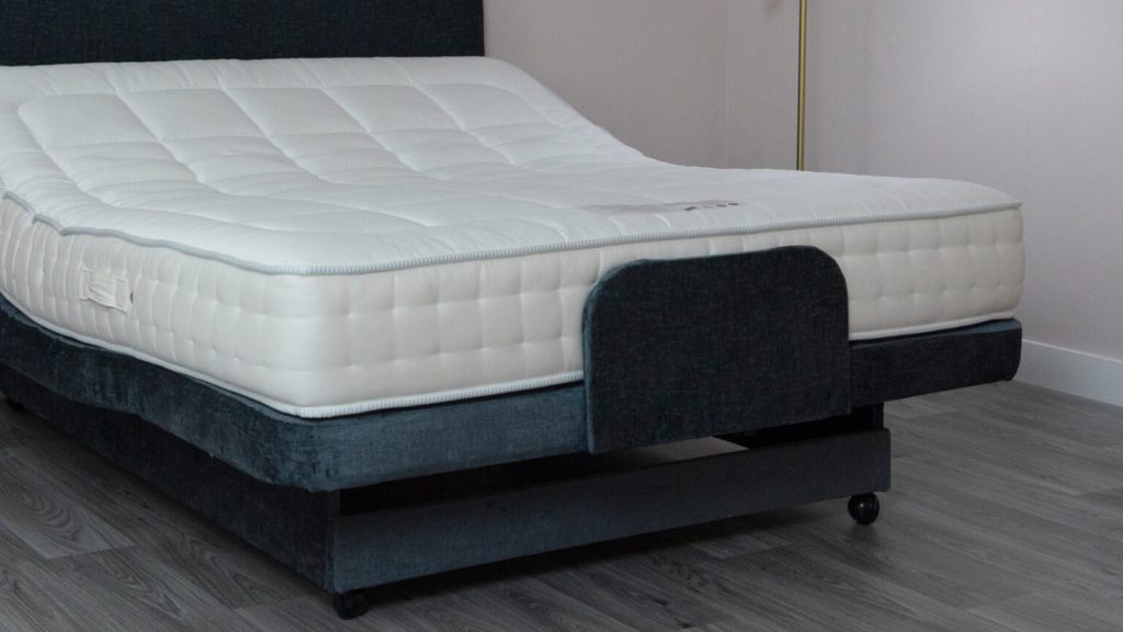 A close-up of a portion of an adjustable bed base focused on an angled joint / hinge area