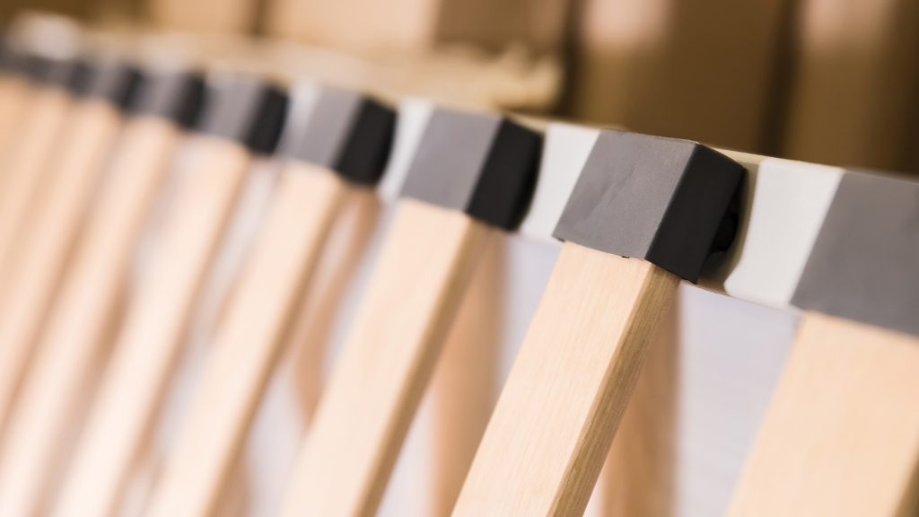 A bed base without a mattress, with slats visible
